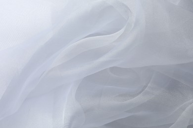 Photo of Texture of white tulle fabric as background, top view