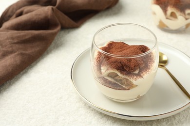 Delicious tiramisu in glass on white table, space for text