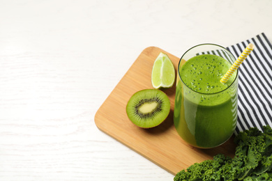 Photo of Tasty fresh kale smoothie on white wooden table. Space for text