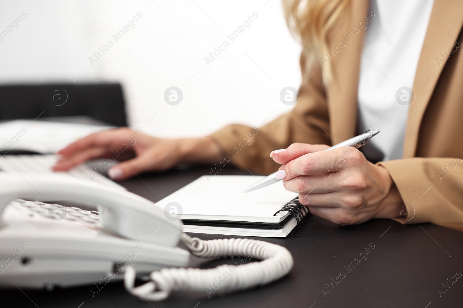 Photo of Secretary taking notes at table in office, closeup