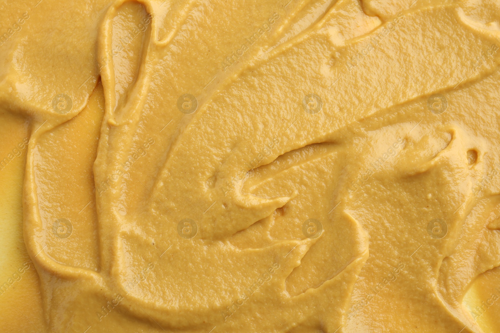 Photo of Fresh tasty mustard sauce as background, top view