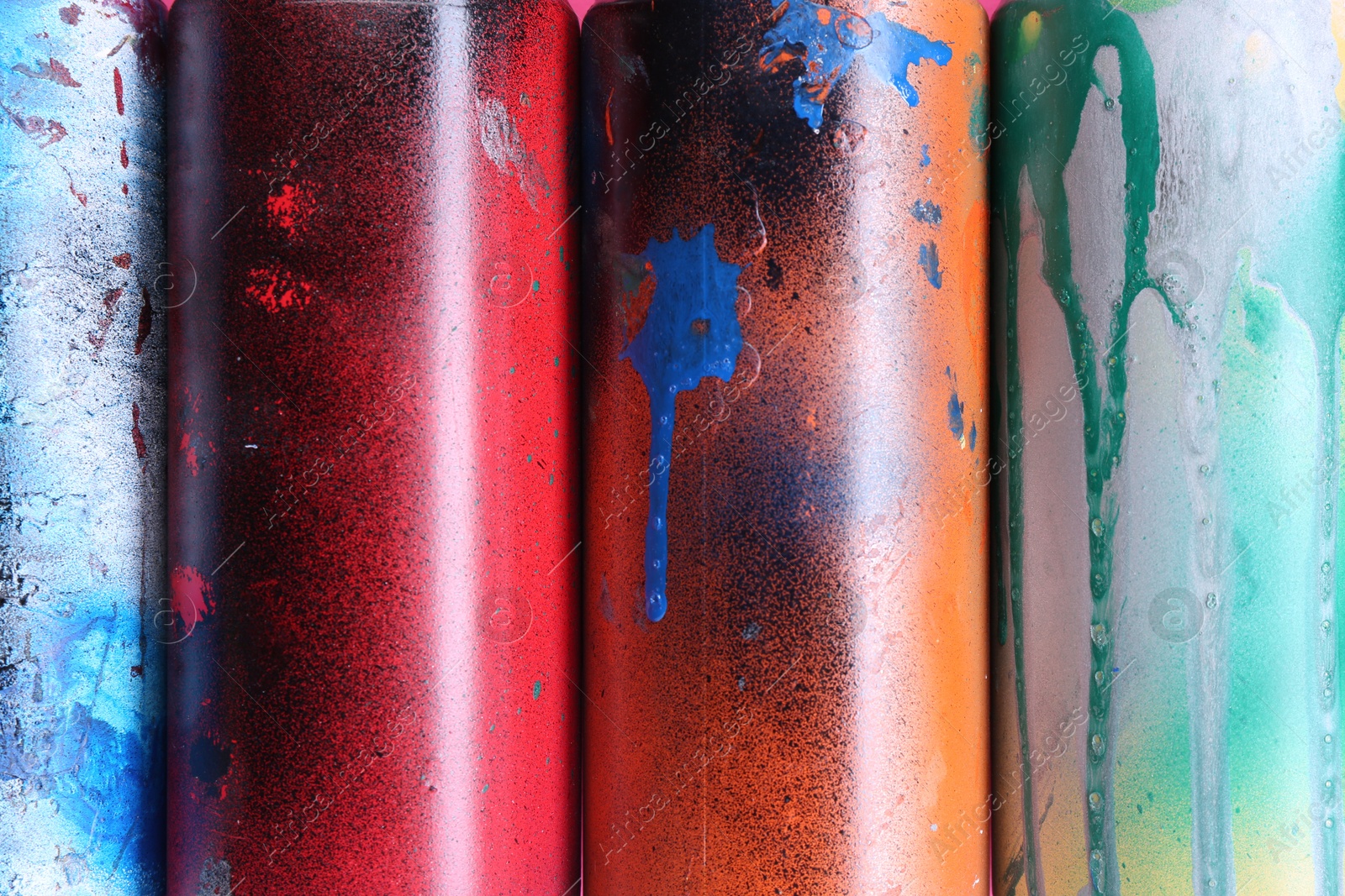 Photo of Different spray paint cans as background, top view