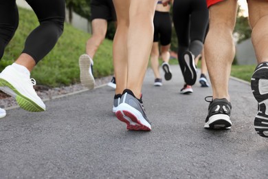 Group of people running outdoors, closeup view