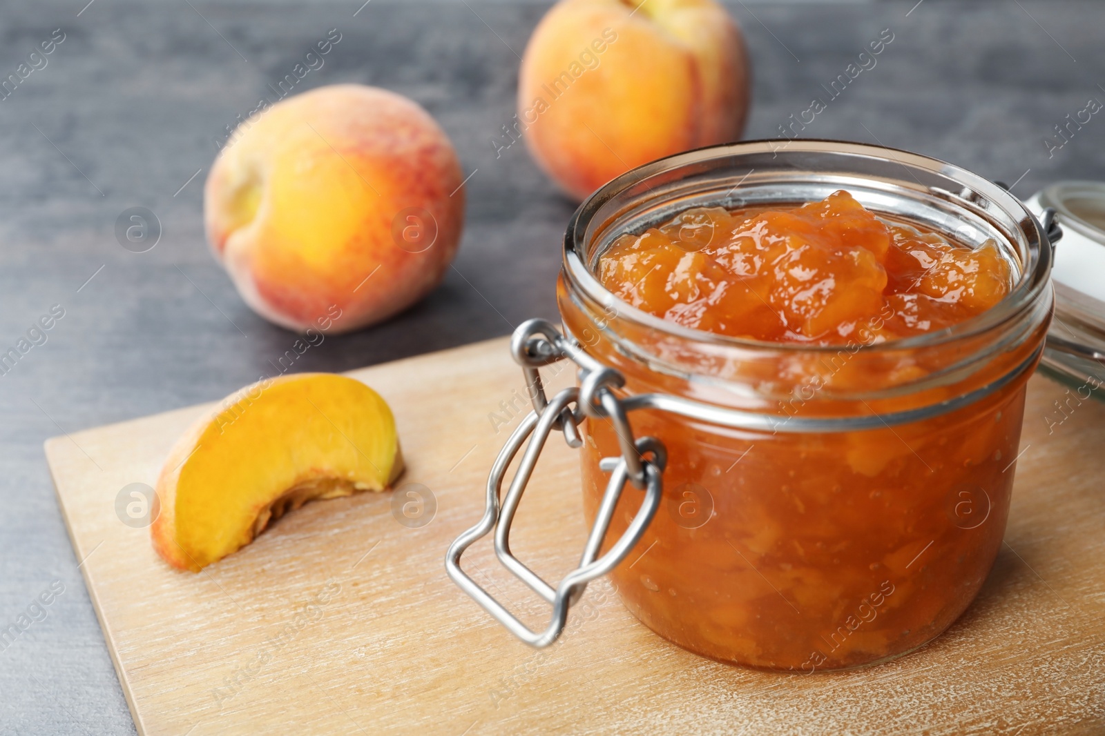 Photo of Jar with tasty peach jam on table