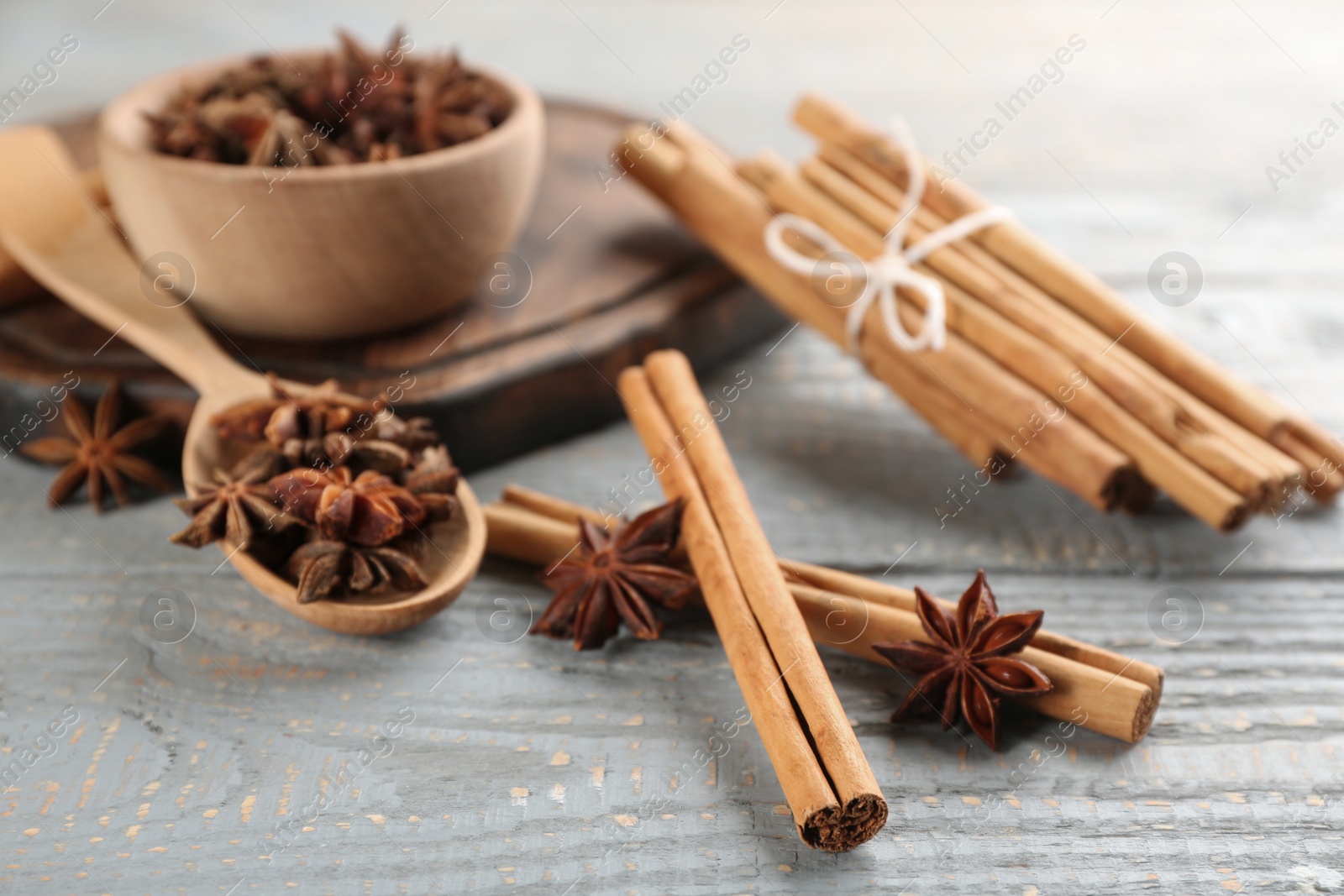 Photo of Aromatic cinnamon sticks and anise on grey wooden table