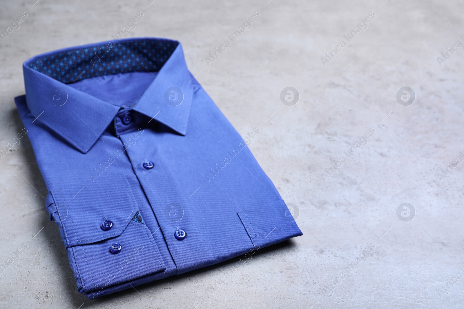 Photo of Stylish blue shirt on grey background. Dry-cleaning service