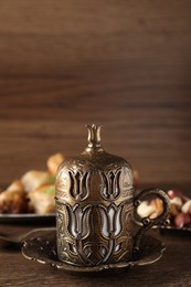 Beautiful vintage cup holder, nuts and baklava dessert on wooden table, space for text