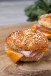 Photo of Delicious bagels with ham and cheese on wooden table, closeup