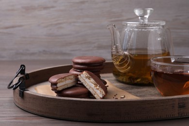 Tasty choco pies and tea on wooden tray