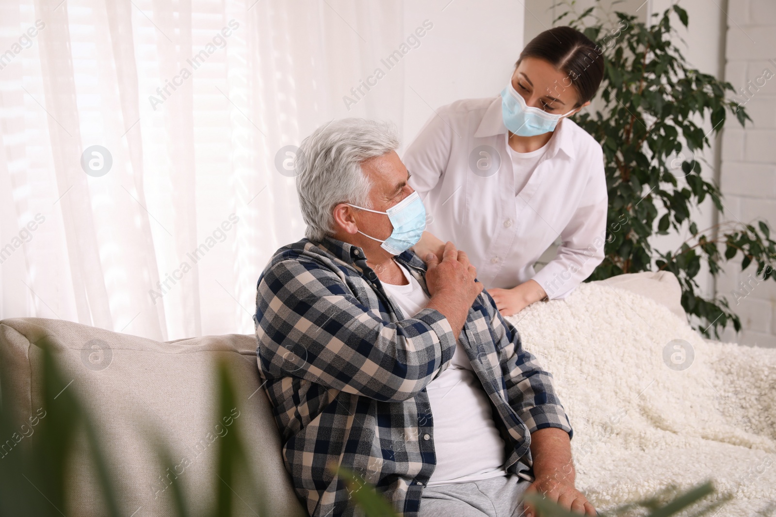 Photo of Doctor taking care of senior man with protective mask at nursing home