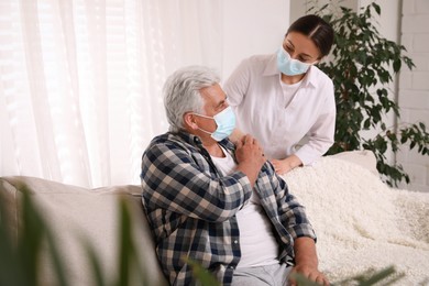 Photo of Doctor taking care of senior man with protective mask at nursing home