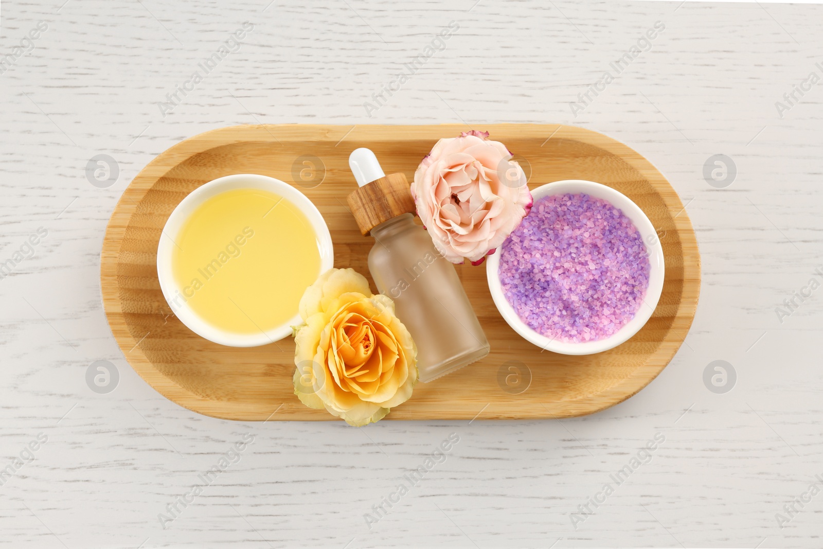 Photo of Purple sea salt, beautiful flowers and different spa products on white wooden table, top view