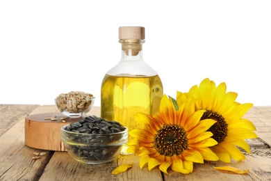 Photo of Composition with sunflower oil on wooden table against white background