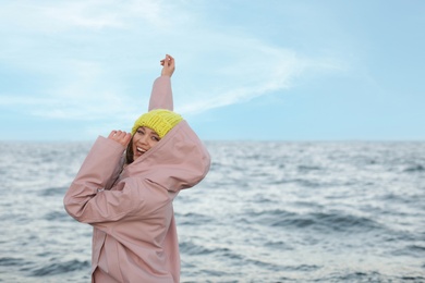 Photo of Stylish young woman spending time near sea