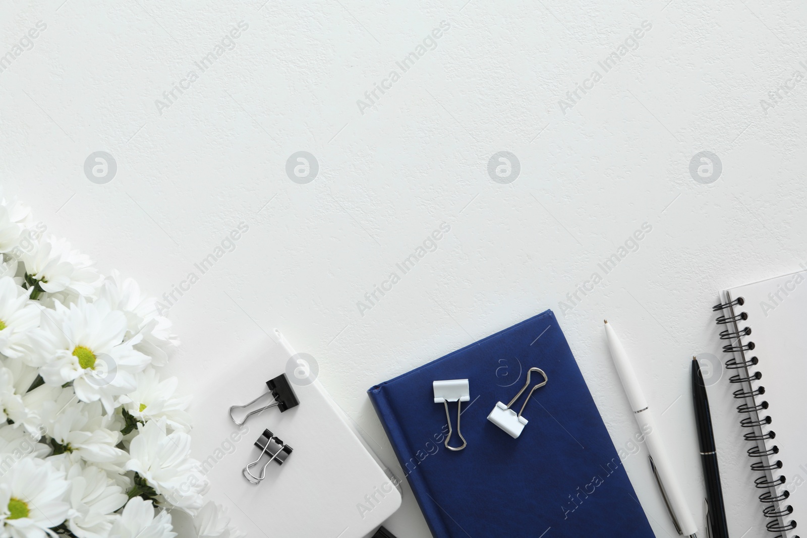 Photo of Beautiful flowers and stationery on white background, flat lay with space for text. Teacher's Day