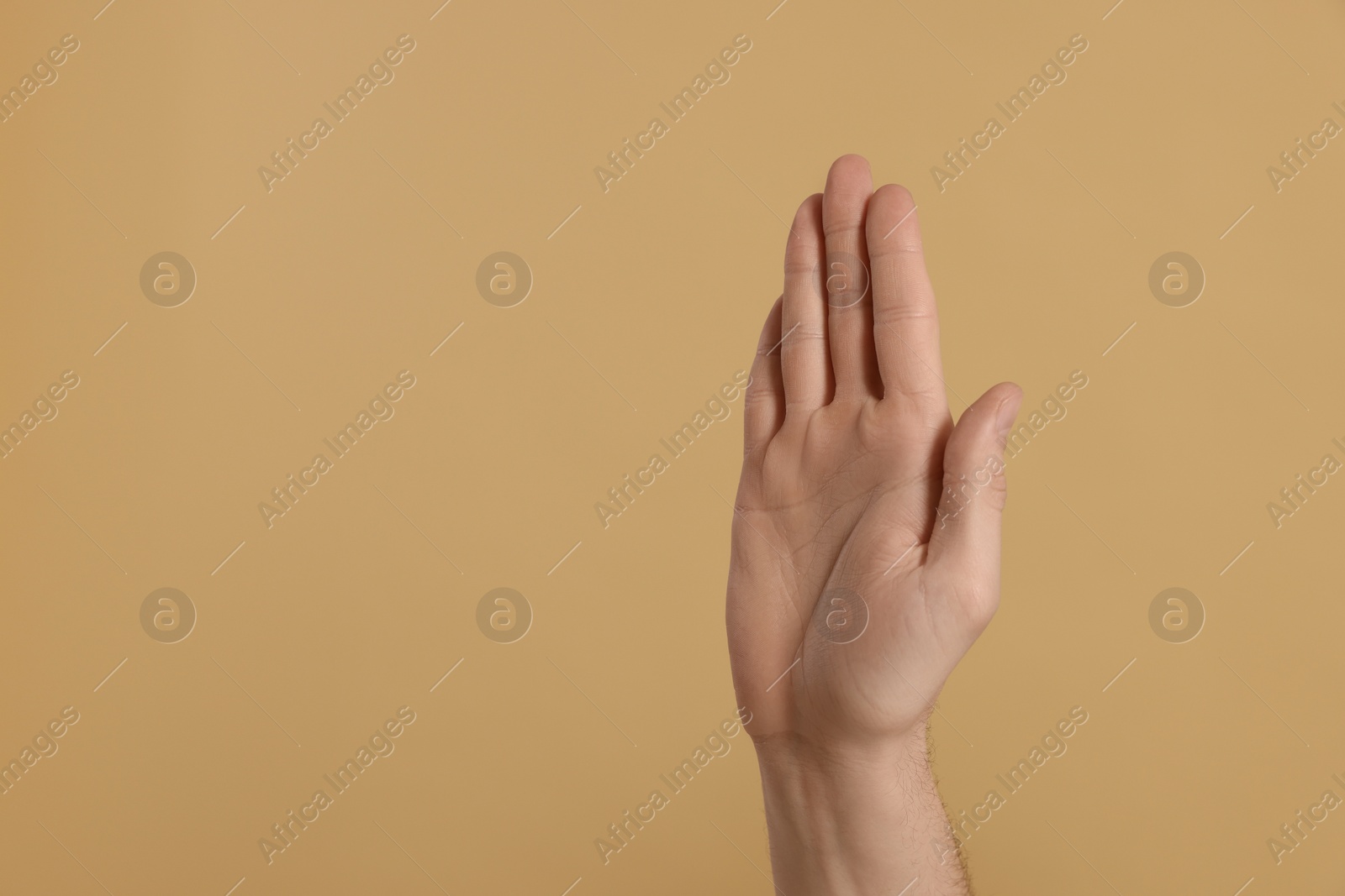 Photo of Man giving high five on beige background, closeup of hand. Space for text