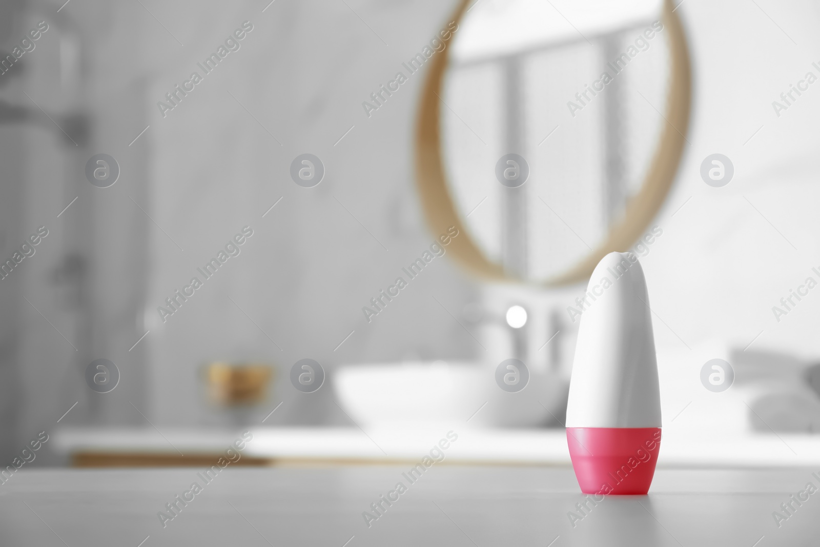 Photo of Deodorant container on table in bathroom. Space for text