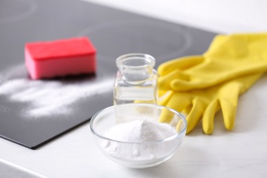 Photo of Baking soda, vinegar and gloves on white table. Eco friendly detergent