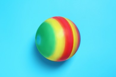 Photo of New bright kids' ball on light blue background, top view