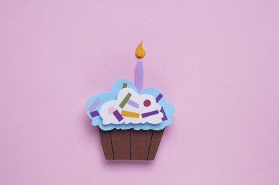 Photo of Birthday party. Paper cupcake on pink background, top view