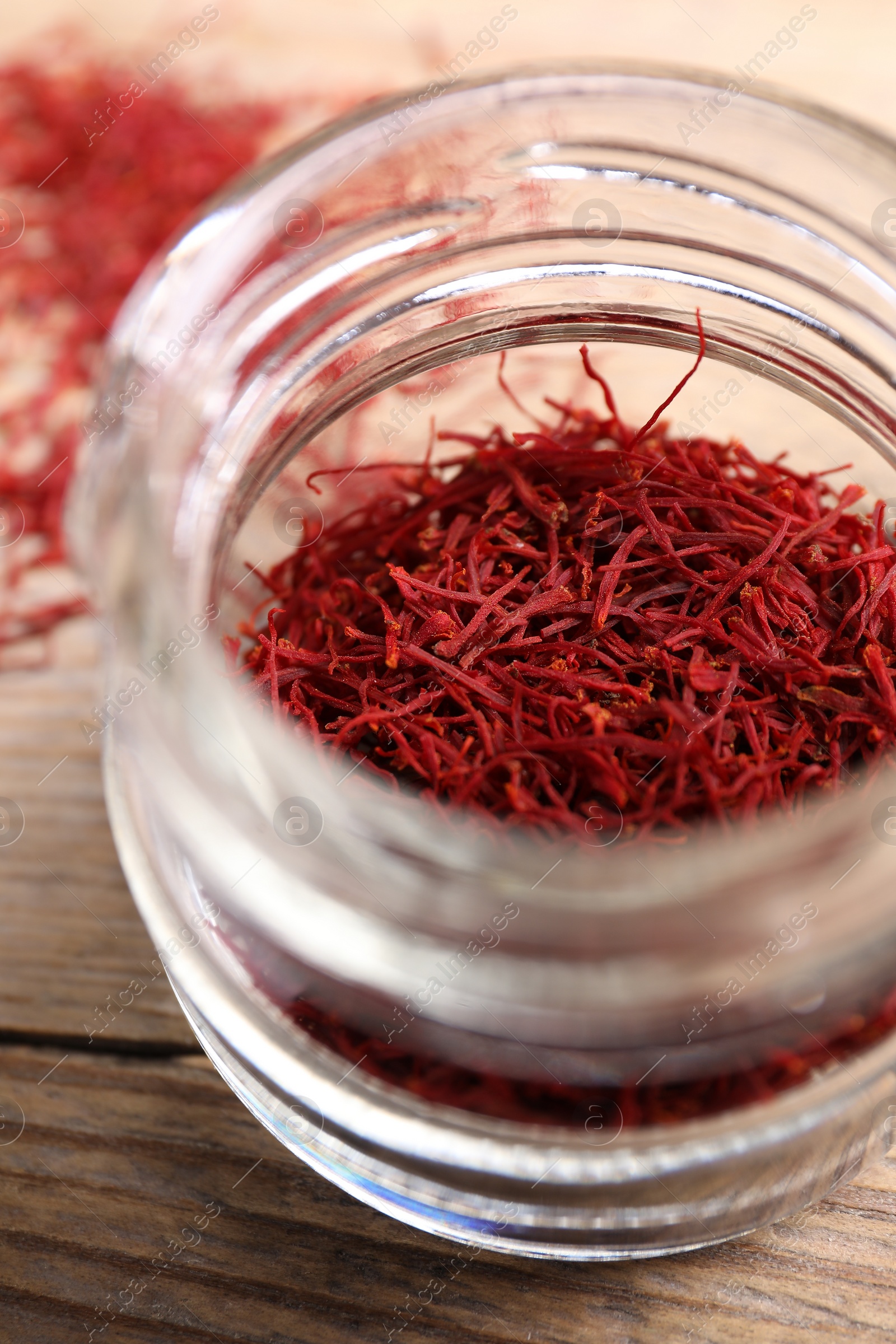 Photo of Aromatic saffron in glass jar on table, closeup