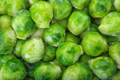 Photo of Frozen brussel sprouts as background, top view. Vegetable preservation