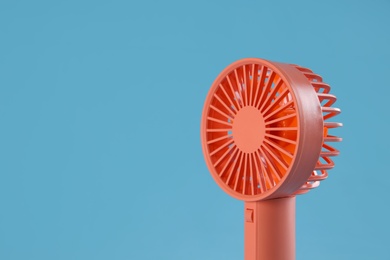 Photo of Modern electric fan on light blue background. Space for text