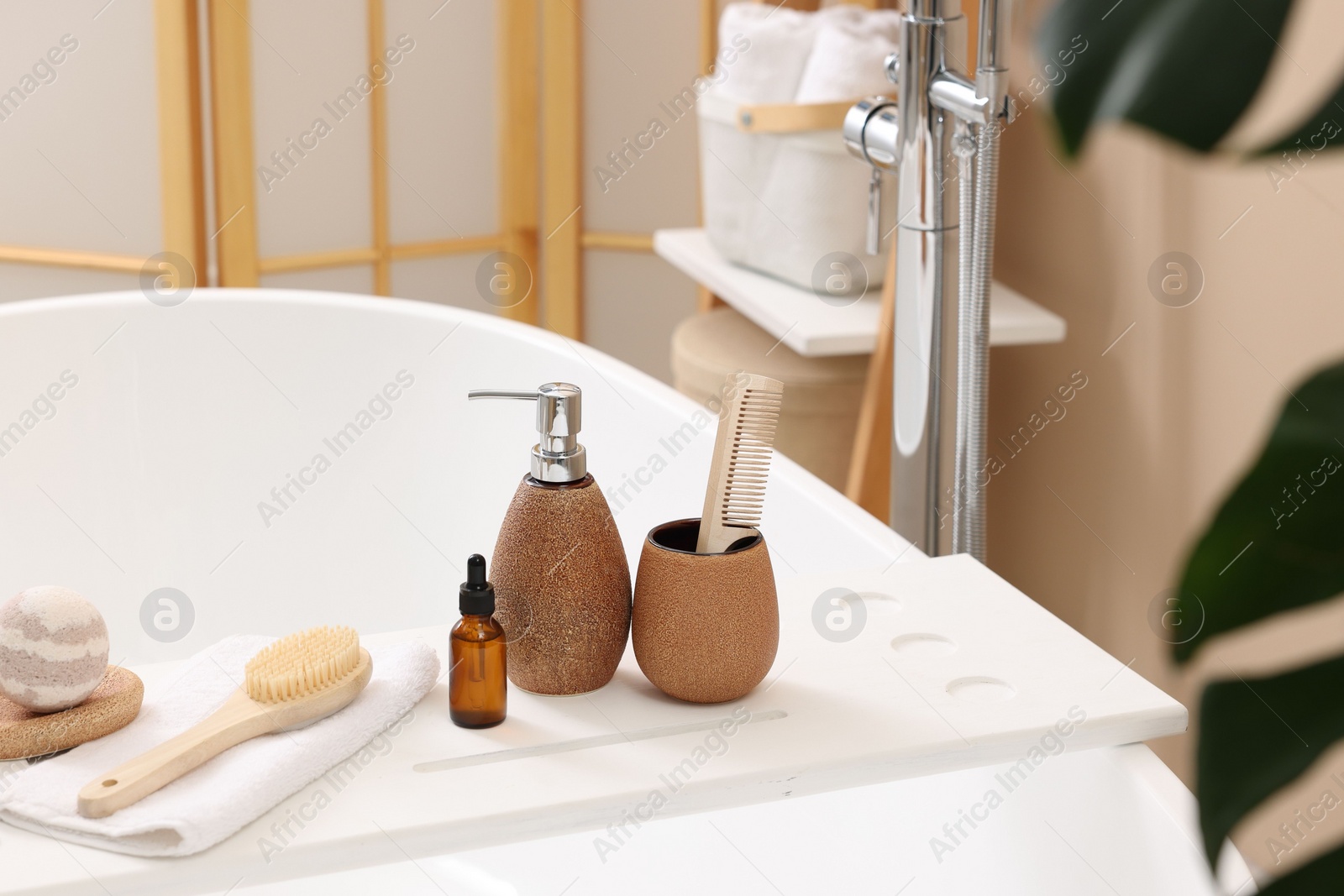 Photo of Different personal care products and accessories on bath tub in bathroom