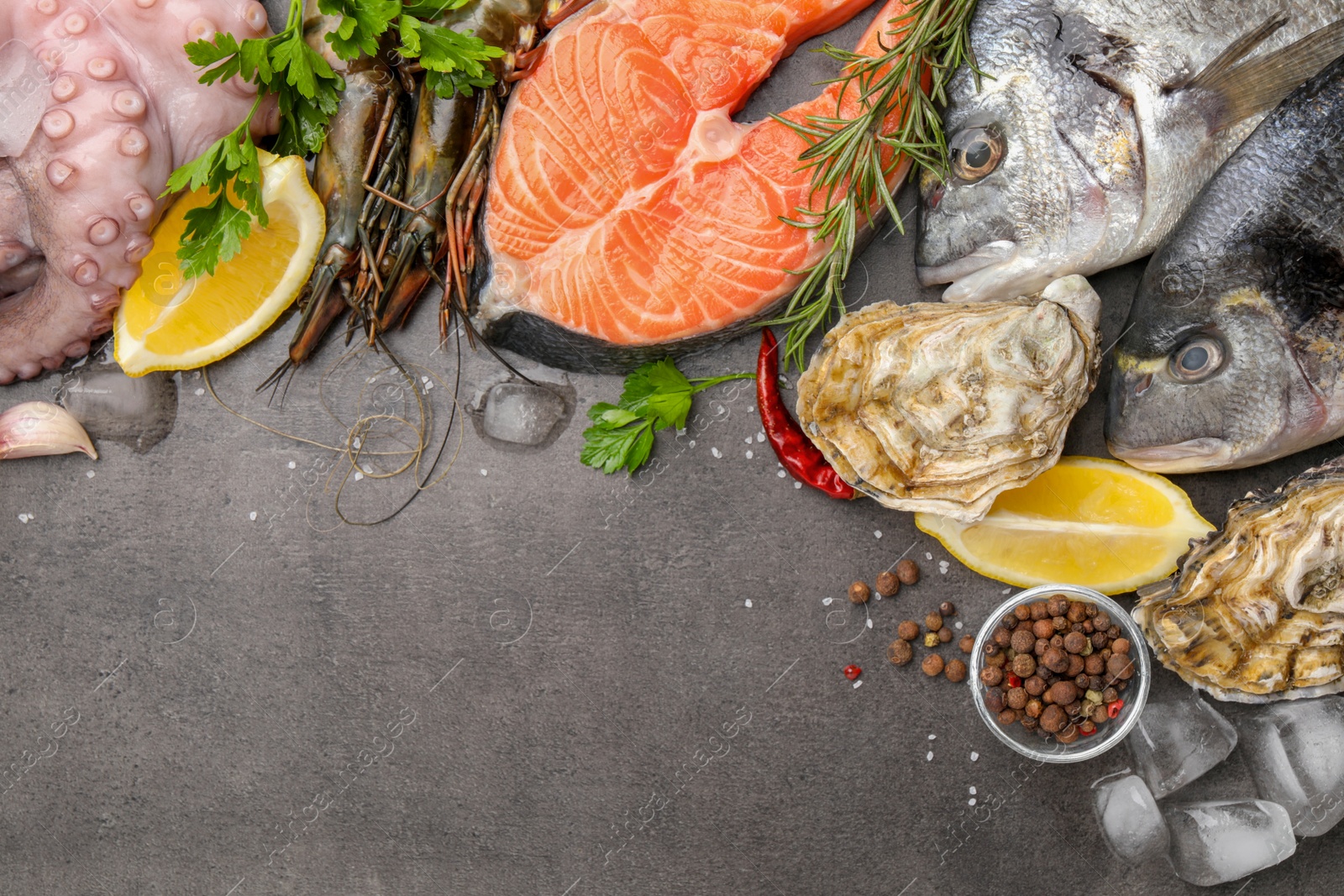 Photo of Flat lay composition with fresh raw dorado fish and different seafood on grey table. Space for text