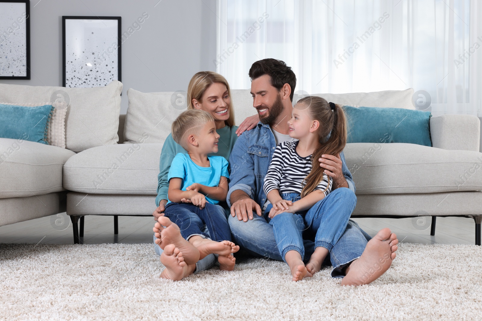 Photo of Happy family spending time together on soft carpet at home