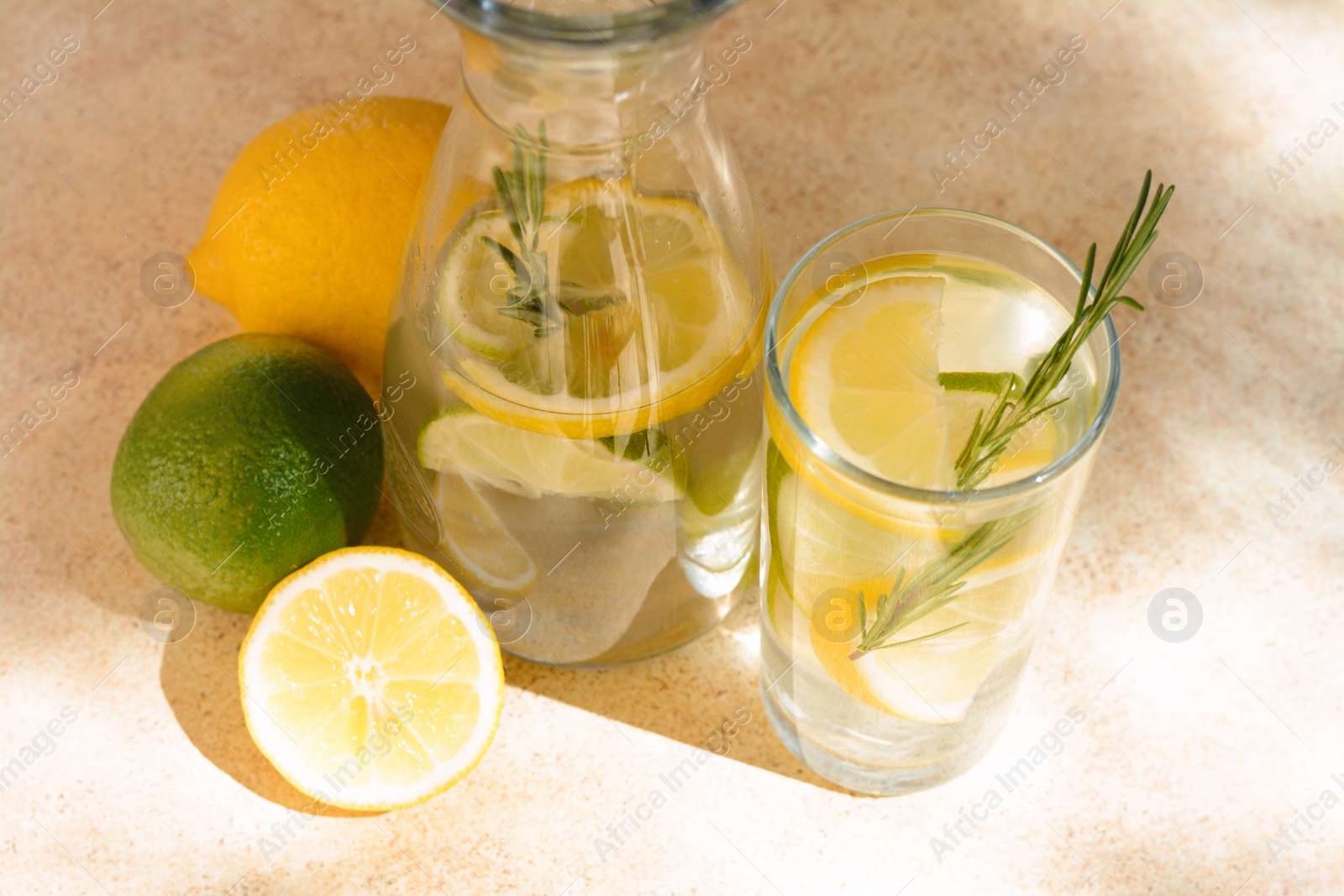 Photo of Tasty refreshing lemonade and ingredients on light table. Summer drink