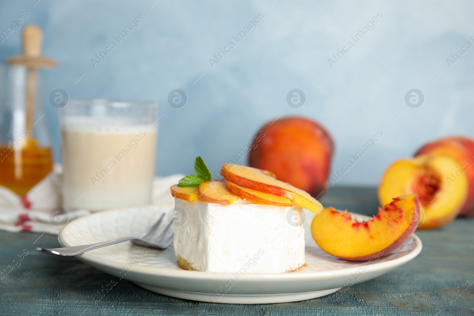 Photo of Delicious peach dessert on blue wooden table