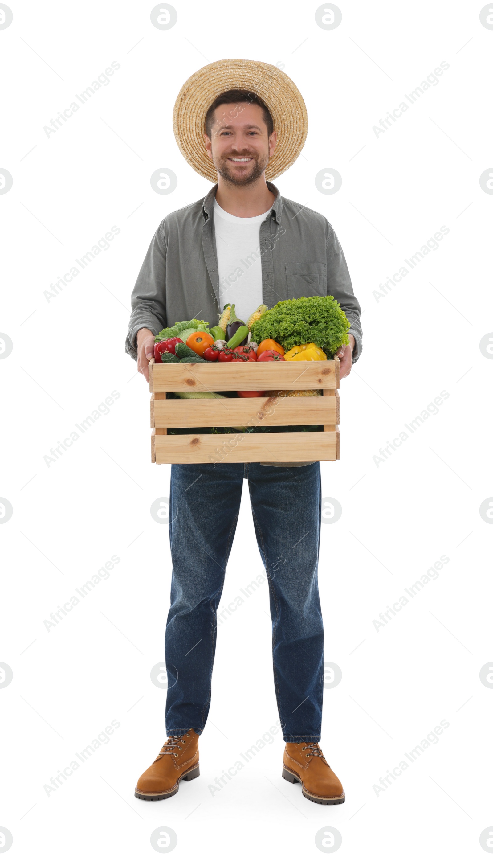 Photo of Harvesting season. Happy farmer holding wooden crate with vegetables on white background