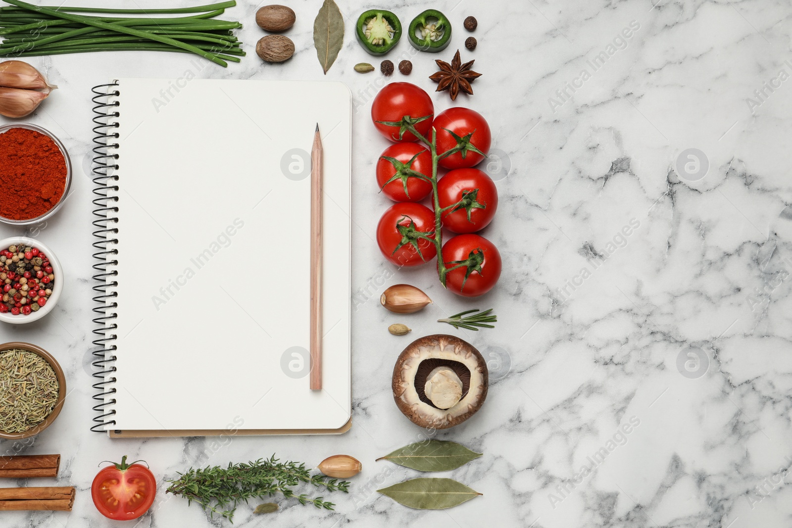 Photo of Open recipe book and different ingredients on white marble table, flat lay. Space for text