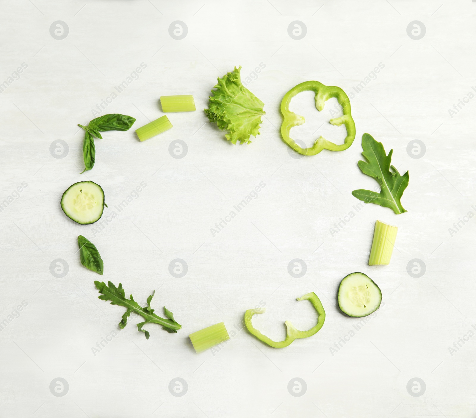 Photo of Frame made with fresh salad ingredients on white wooden table, flat lay. Space for text