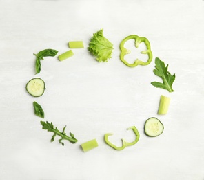 Frame made with fresh salad ingredients on white wooden table, flat lay. Space for text