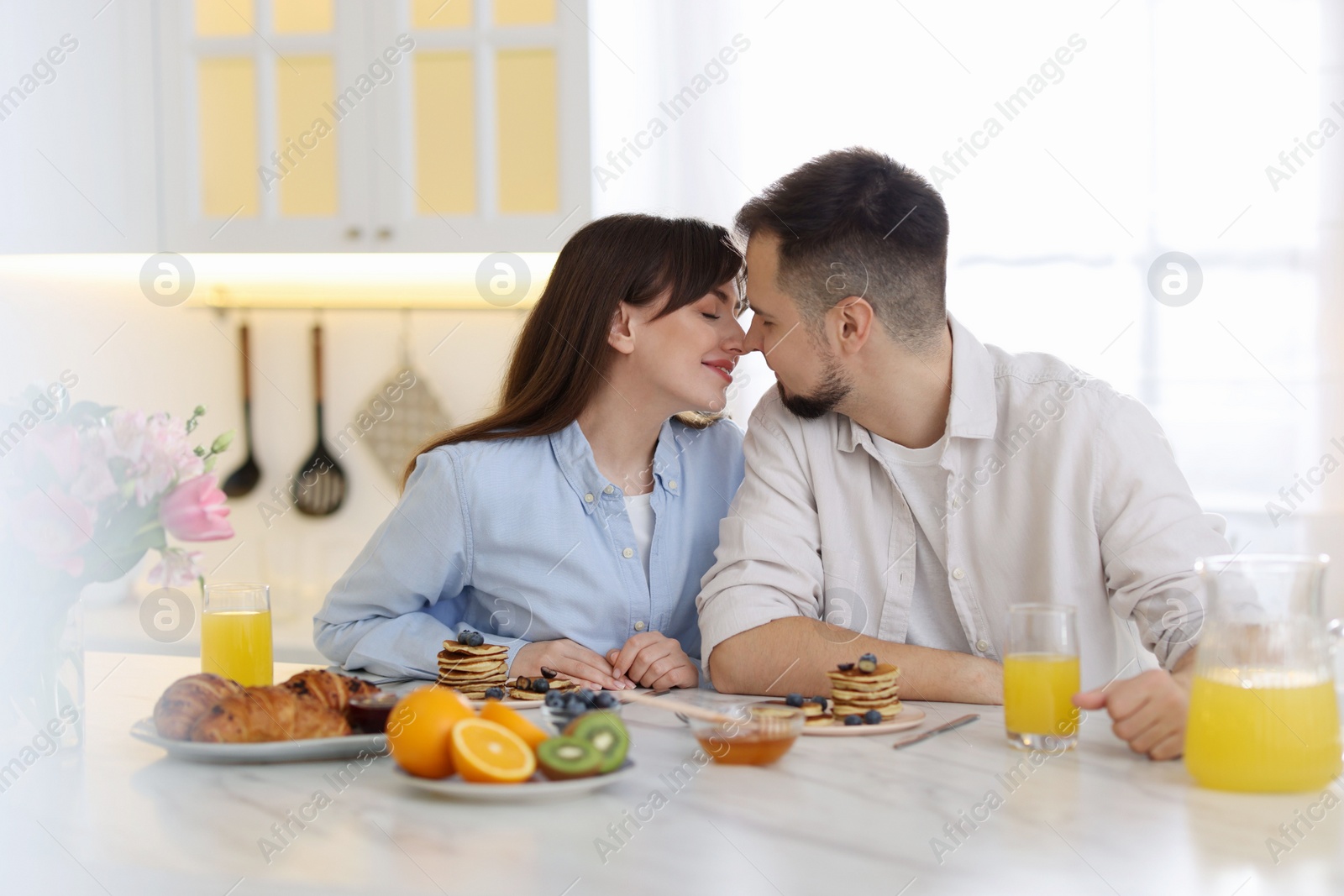 Photo of Happy couple spending time together during breakfast at home