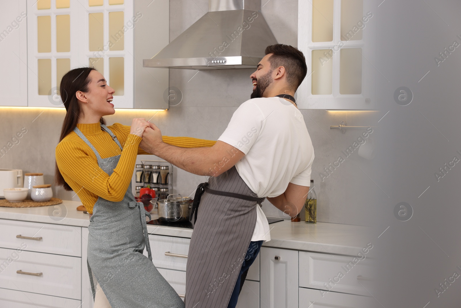 Photo of Happy lovely couple dancing together in kitchen