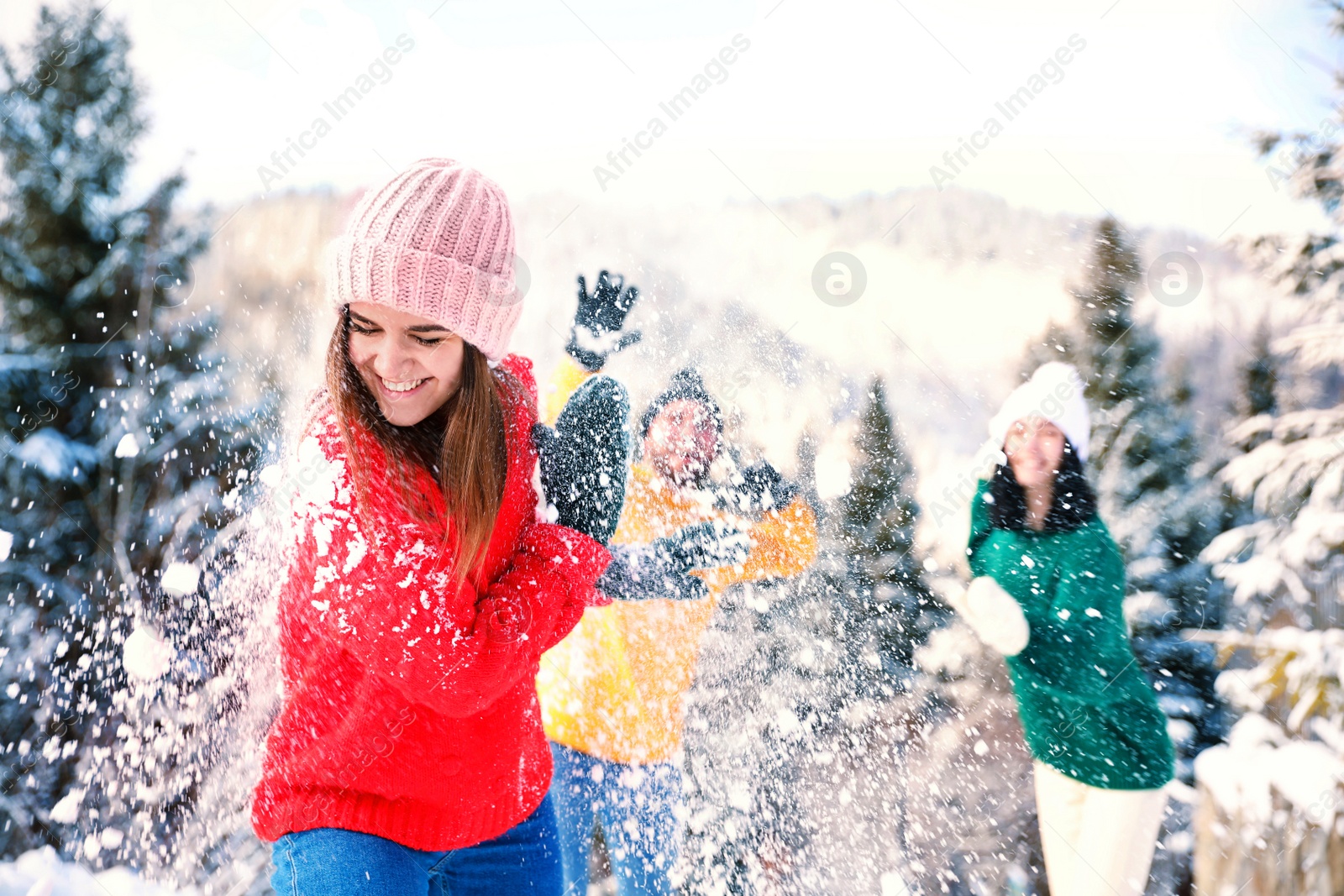 Photo of Happy friends playing snowballs outdoors. Winter vacation