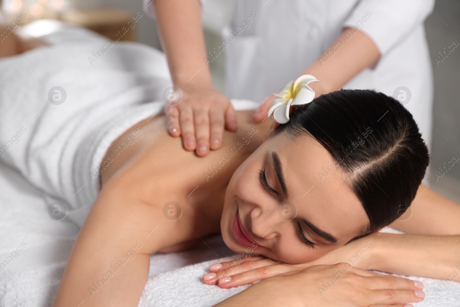 Photo of Beautiful woman receiving back massage in beauty salon, closeup