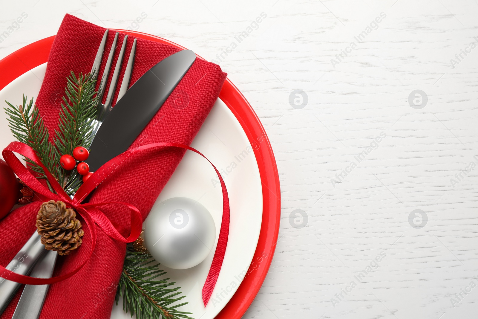 Photo of Festive table setting with beautiful dishware and Christmas decor on white wooden background, top view. Space for text