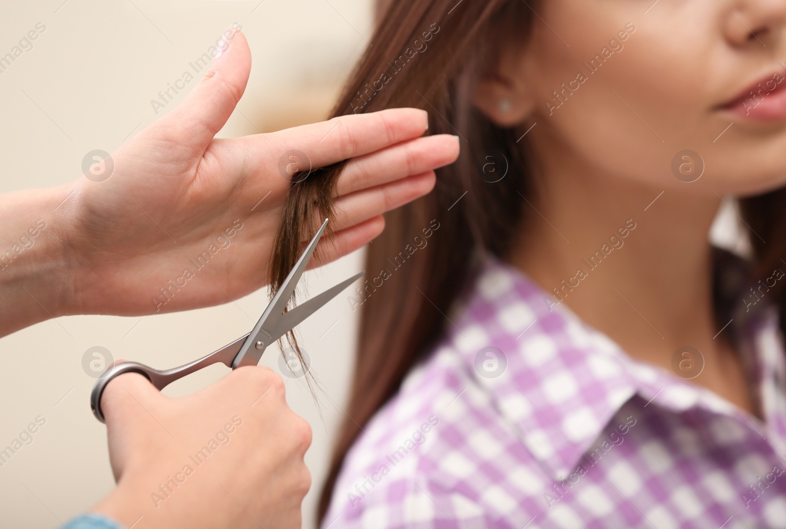 Photo of Barber making stylish haircut with professional scissors in beauty salon, closeup