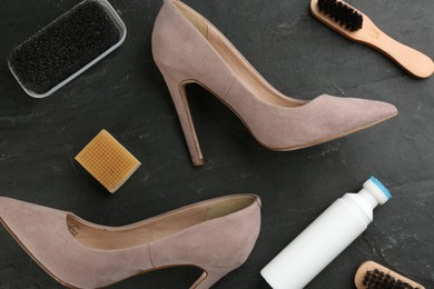 Photo of Stylish footwear with shoe care accessories on black table, flat lay