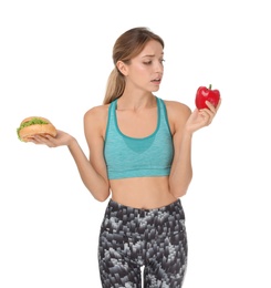 Photo of Young woman holding burger and bell pepper on white background. Choice between diet and unhealthy food