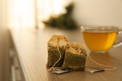 Two used tea bags on wooden table