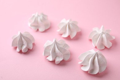 Photo of Many tasty meringue cookies on pink background