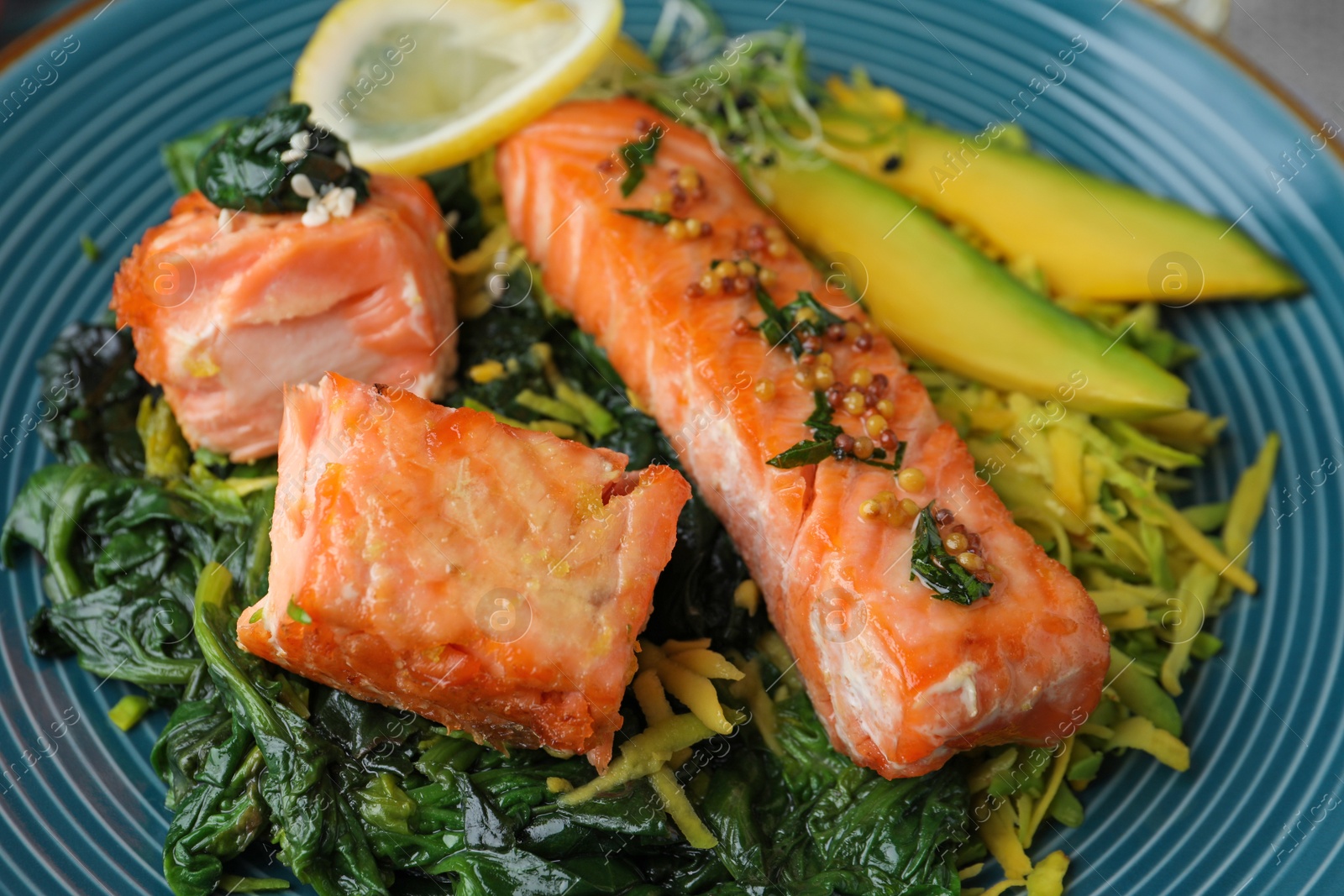 Photo of Tasty freshly cooked salmon with spinach on plate, closeup