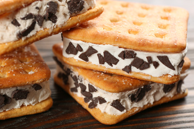 Photo of Sweet delicious ice cream cookie sandwiches on wooden table, closeup