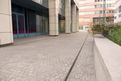 Tiled pavement near building outdoors. Sidewalk covering