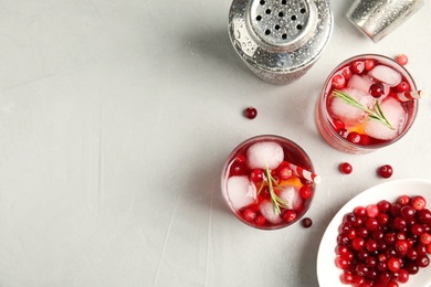 Tasty refreshing cranberry cocktail on light grey table, flat lay. Space for text